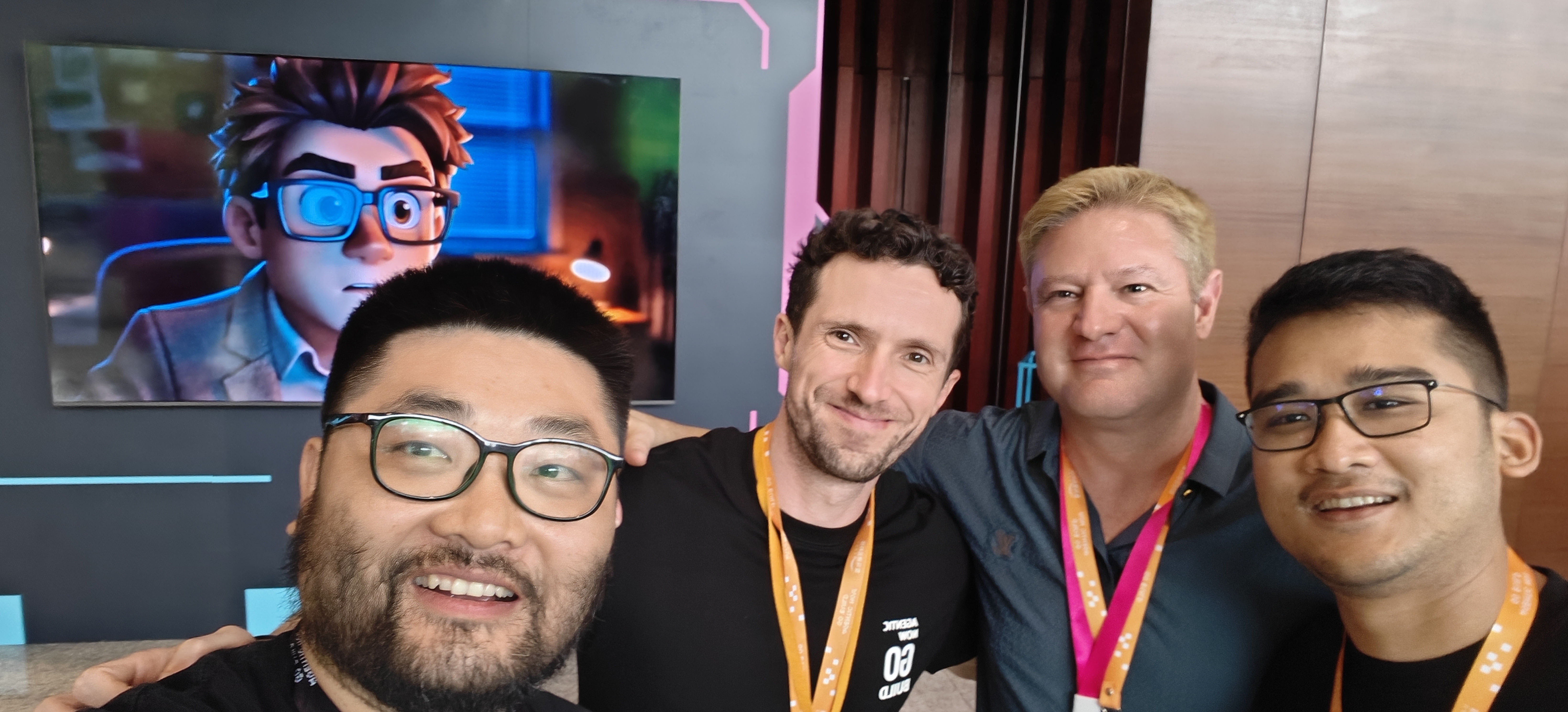 上海 Summit — 与作者合影，大屏是 Agentic「NOW GO BUILD」形象