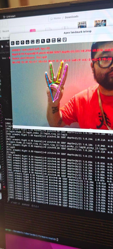 用手机拍下的展台屏幕：ARMED，real robot=left，39 fps，Kapandji HUD 与终端日志同屏